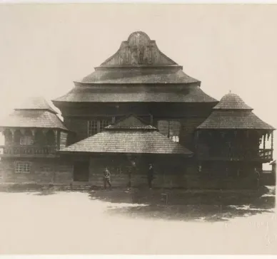 Black and white photograph of the western facade, people standing in front of it.
