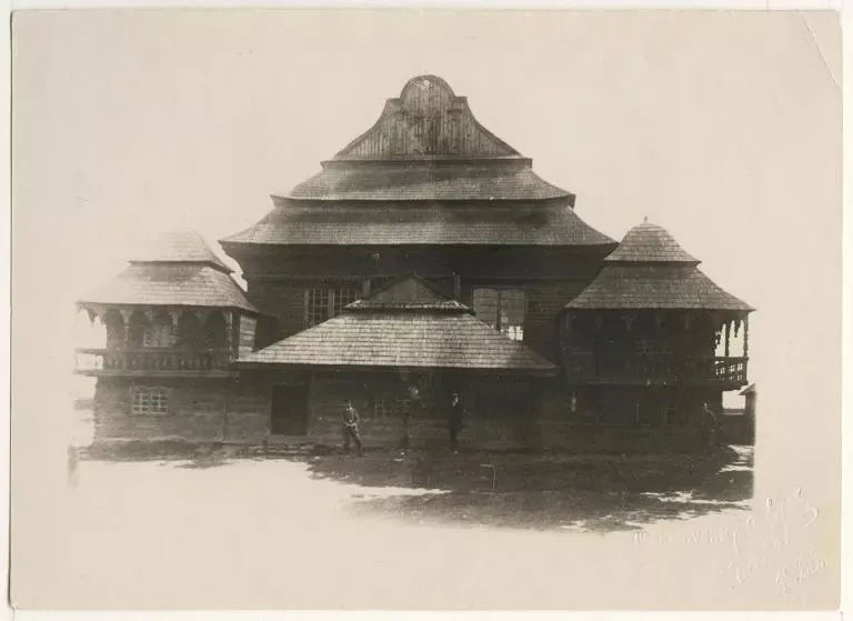 Black and white photograph of the western facade, people standing in front of it.