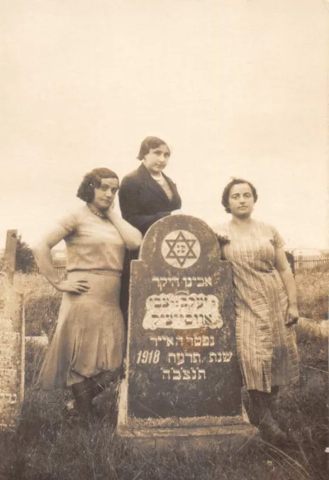 Photo of three women. They are the sisters of Harvey Sohnen’s grandmother. Rezia was a teacher, Nechama a housewife, and Lea owned a grocery. They were all murdered during the Holocaust. They stand near their father’s grave in the Jewish graveyard of Oshmyany. The photo was been taken between May 1929 and the Second World War. The inscription in Yiddish on the back of the photograph says: “Remember Father's yortsayt”. 